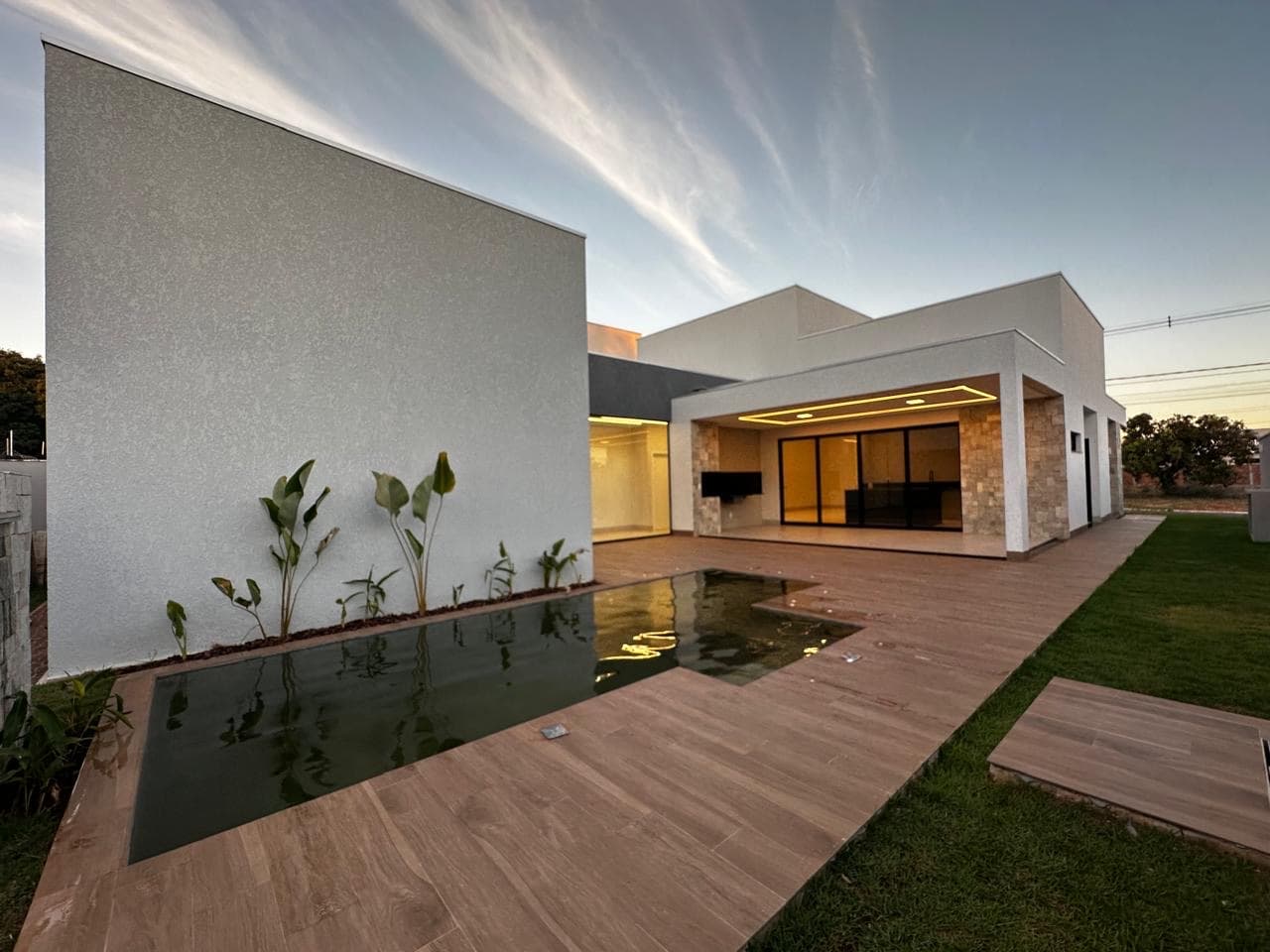 Piscina com cascata e deck da casa